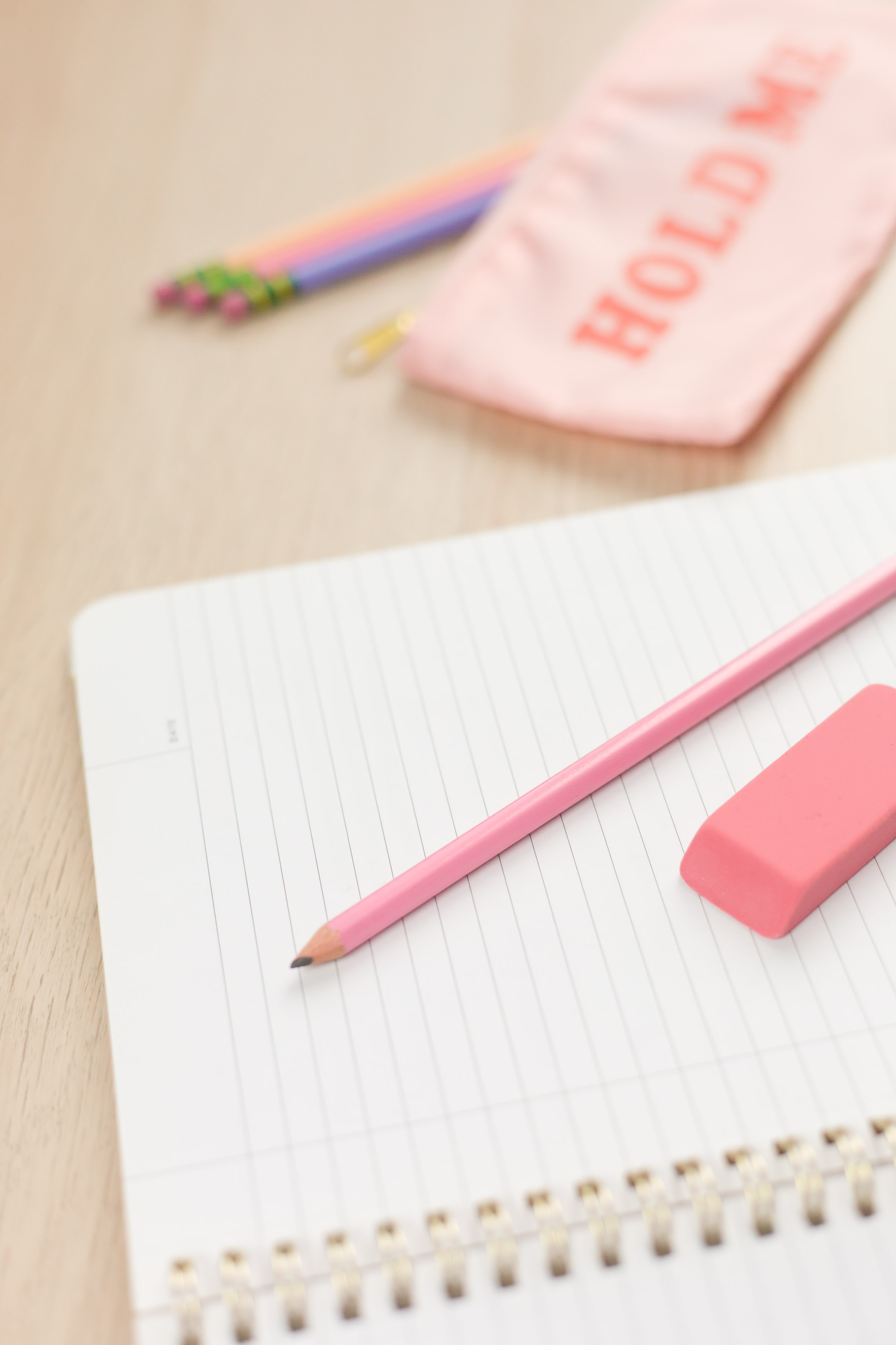 open notebook with a pink pencil and a pink eraser on top
