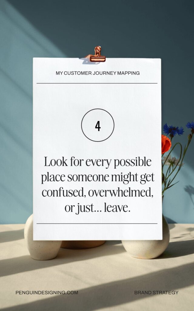 A paper with text reads: "Look for every possible place someone might get confused, overwhelmed, or just... leave." It is clipped upright on a stand with flowers in the background—perfect advice for the customer journey mapping process.