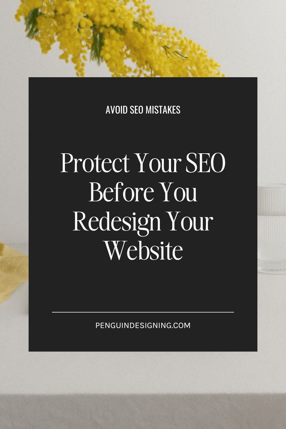Black box with white text reads “Protect Your SEO Before You Redesign Your Website” on a table with yellow flowers and a glass of water, emphasizing the importance of safeguarding your SEO during a website redesign.