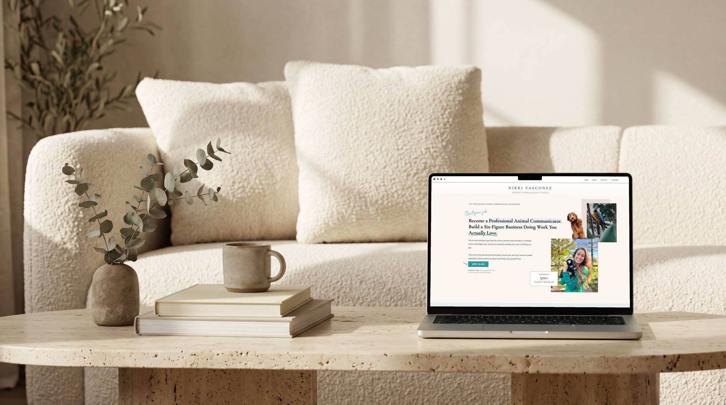 A laptop on a coffee table displaying the sales page redesign for animal communicator teacher Nikki Vasconez.
